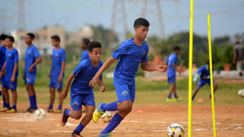 Kinder und Jugendliche aus lokalen Gemeinden in Salvador erhalten Fußballunterricht mit Trainern aus einem anderen Land;  verstehe