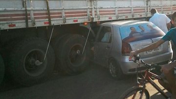 Imagem Carro para embaixo de carreta em acidente e motorista sai ilesa