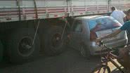 Imagem Carro para embaixo de carreta em acidente e motorista sai ilesa