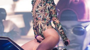 Imagem Miley Cyrus veste roupa com estampa de maconha e se toca no palco