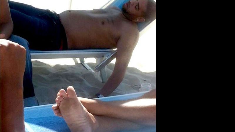 Imagem Com futuro incerto, Adriano é flagrado dormindo de calça na praia