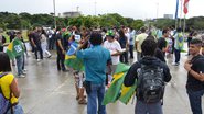 Imagem Manifestantes cobrem monumento Luis Eduardo com bandeira de Mariguella