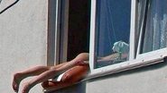 Imagem Mulher toma banho de sol nua na janela de prédio e causa caos no trânsito