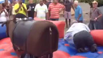 Imagem Segura peão: Lúcio Vieira Lima tenta montar boi mecânico e paga mico