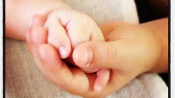 Imagem Claudia Leitte mostra foto do filho Davi segurando mãozinha do irmão Rafael