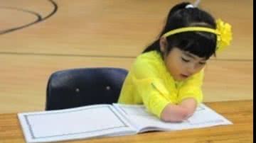 Imagem Menina que nasceu sem as mãos ganha concurso de caligrafia