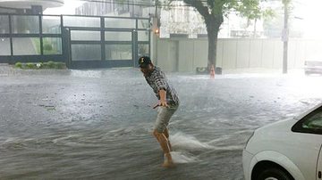 Imagem Em meio a temporal, Ashton Kutcher "surfa" nas ruas de SP