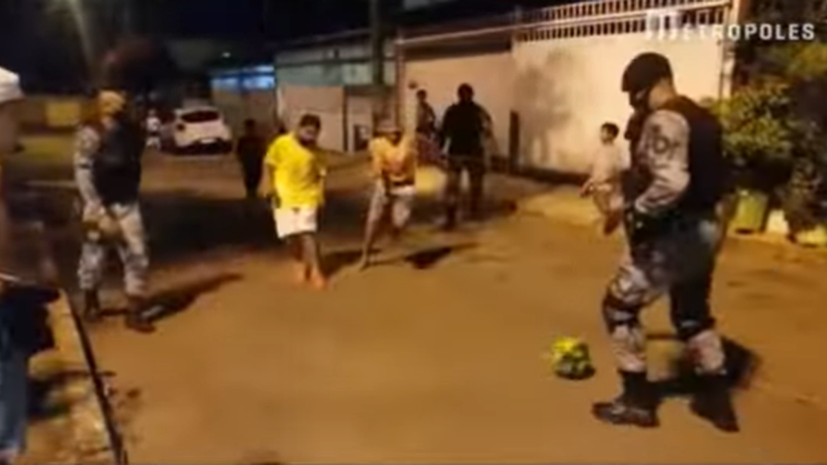 Policiais aceitam convite de crianças e jogam bola na rua durante