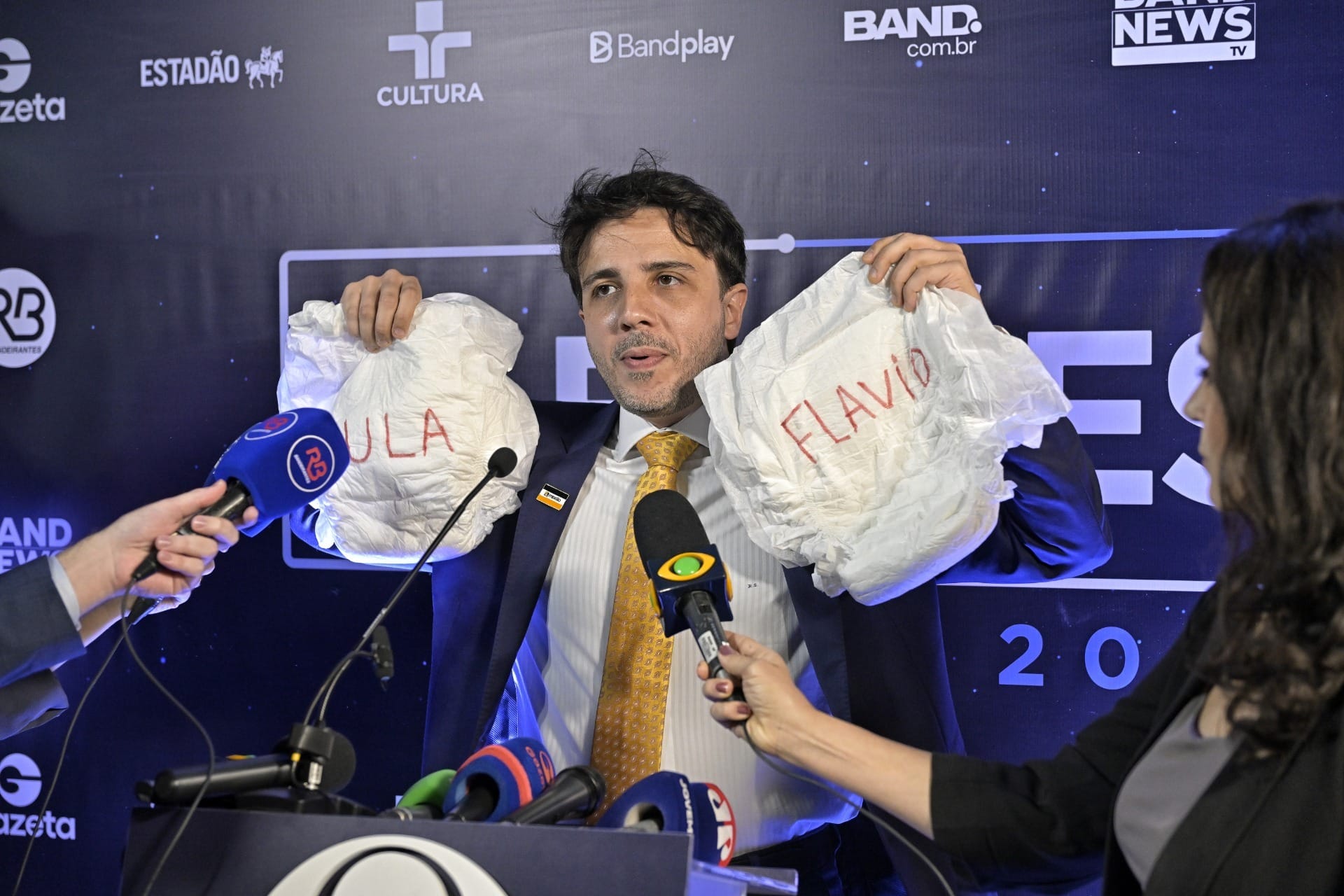 Antes do programa começar, Renan mostrou fraudas com o nomes dos dois candidatos a jornalistas presentes no local - Imagem: Renato Pizzutto/Band