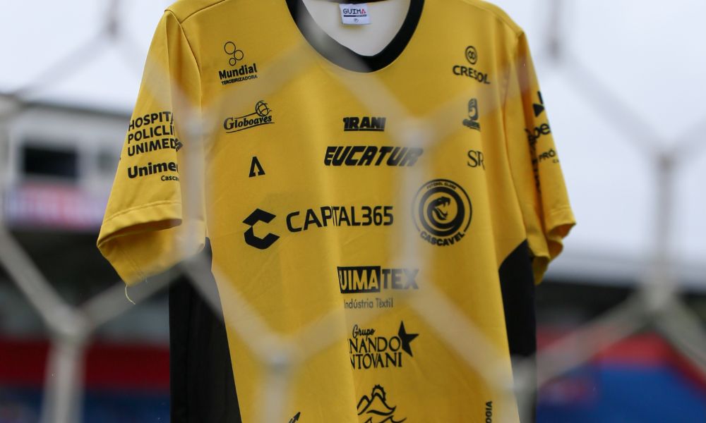 Imagem da camisa do Cascavel pendurada na rede de um campo de futebol