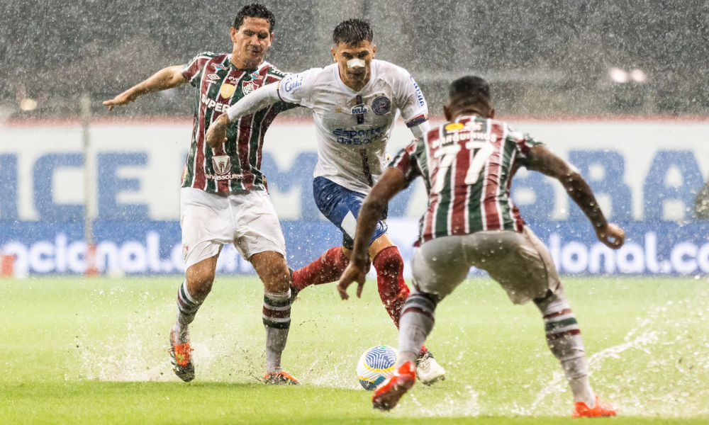 Jogadores de Bahia e Fluminense jogando em meio ao gramado encharcado da Fonte Nova