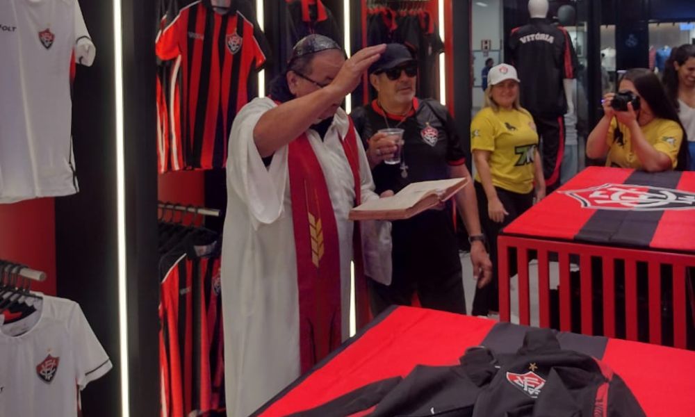 Padre fazendo oração em loja do Vitória