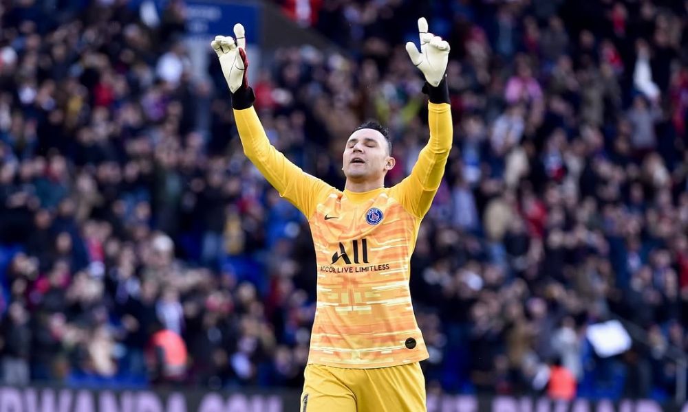 Foto de Keylo Navas agradecendo a Deus e atuando com a camisa do PSG